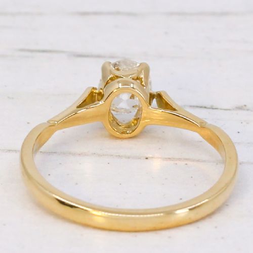 A vintage 1930s yellow gold ring featuring a central claw-set oval cut diamond with tapered shoulders. View V