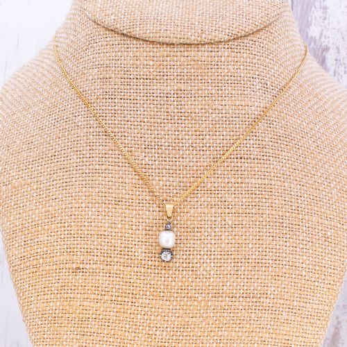 fig 3. An antique gold chain holding a vertical drop pendant featuring a natural pearl suspended between two bezel-set diamonds.