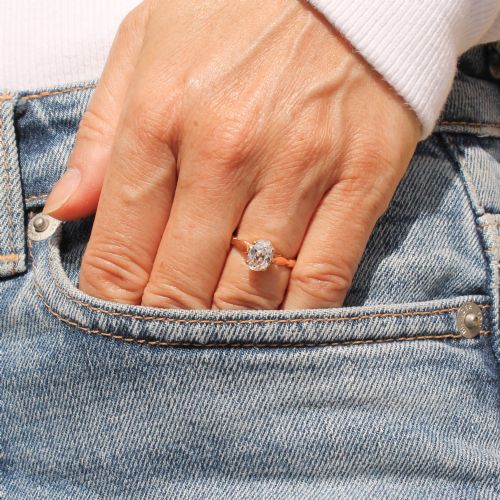 fig 1. An Art Deco period rose gold ring featuring a central old oval cut diamond held in a claw setting with contoured shoulder details.