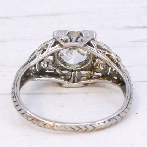 An Art Deco platinum engagement ring featuring a central old European cut diamond set within intricate pierced filigree shoulders. View V