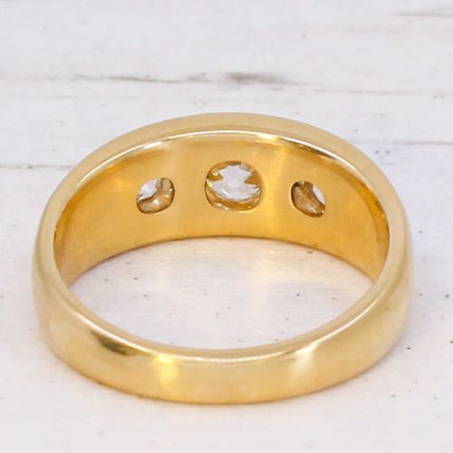 A smooth yellow gold wide band ring featuring three flush-set old cut diamonds across the front. View V