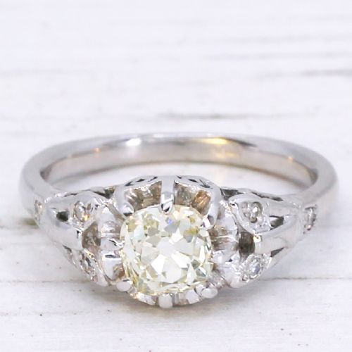 fig 2. An Art Deco style white metal ring featuring a central old European cut diamond set in an ornate pierced basket setting.