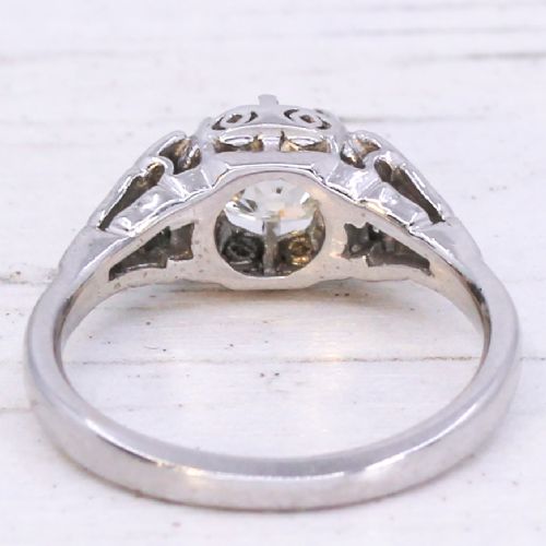 An Art Deco style white metal ring featuring a central old European cut diamond set in an ornate pierced basket setting. View V