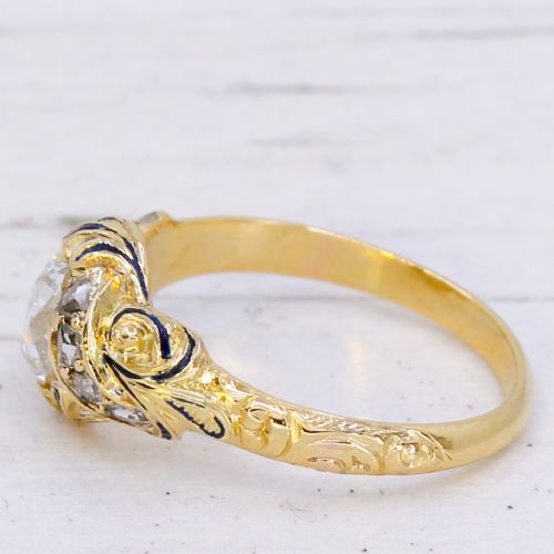 fig 3. A Victorian yellow gold solitaire ring featuring a central old cut diamond surrounded by blue enamel scrollwork and accent diamonds.