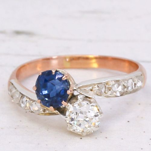 fig 2. An antique Edwardian gold and platinum crossover ring set with a round blue sapphire and a diamond in a Moi et Toi design.