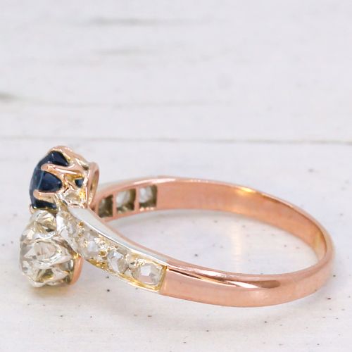 fig 3. An antique Edwardian gold and platinum crossover ring set with a round blue sapphire and a diamond in a Moi et Toi design.