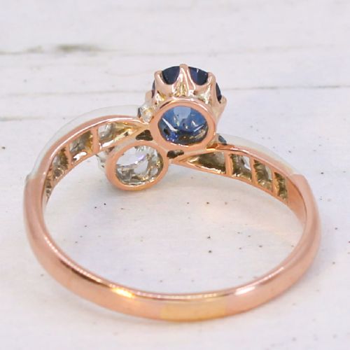 fig 4. An antique Edwardian gold and platinum crossover ring set with a round blue sapphire and a diamond in a Moi et Toi design.