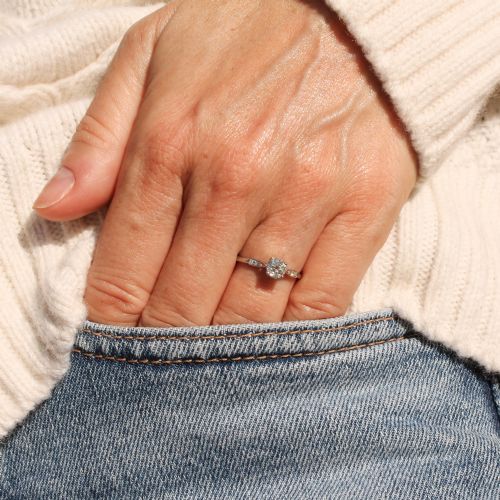 fig 1. A vintage platinum engagement ring featuring a round old cut central diamond flanked by small accent stones set into the shoulders.