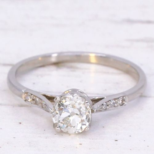fig 2. A vintage platinum engagement ring featuring a round old cut central diamond flanked by small accent stones set into the shoulders.