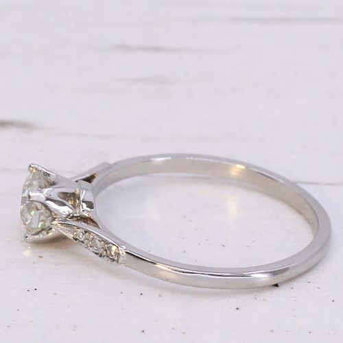 fig 3. A vintage platinum engagement ring featuring a round old cut central diamond flanked by small accent stones set into the shoulders.