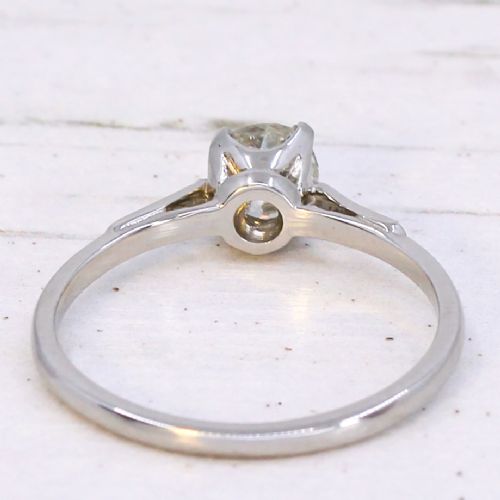 A vintage platinum engagement ring featuring a round old cut central diamond flanked by small accent stones set into the shoulders. View V