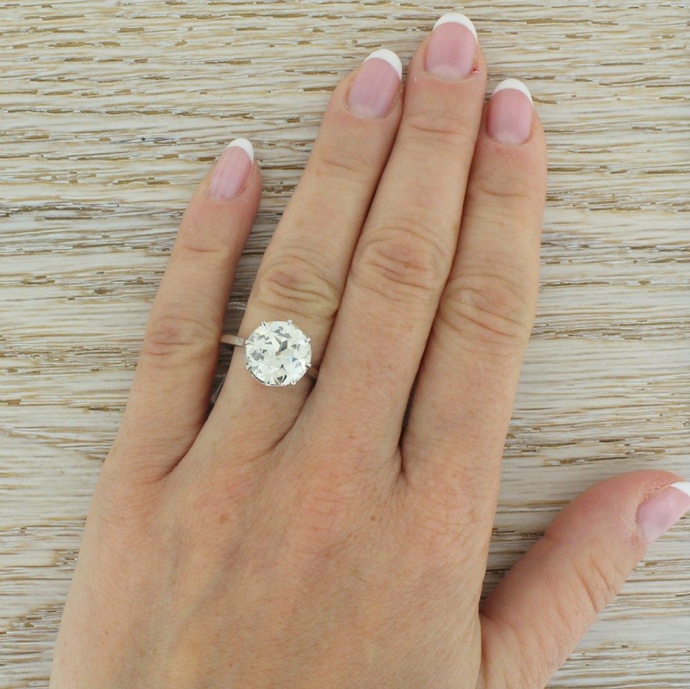An Art Deco diamond solitaire ring featuring a large round Old European cut diamond held in a multi-prong setting on a smooth metal band. View VI