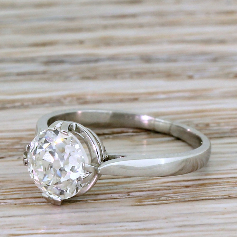 An Art Deco ring crafted in polished silver-toned metal featuring a single central old European cut diamond held in a claw setting.