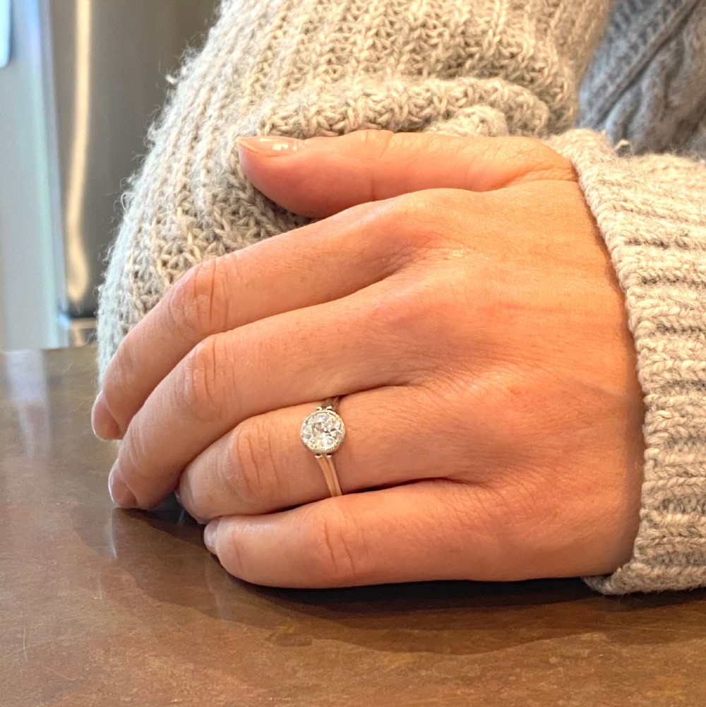 An Art Deco solitaire engagement ring featuring a round old cut diamond set in a milgrained rubover bezel on a platinum band. View VIII