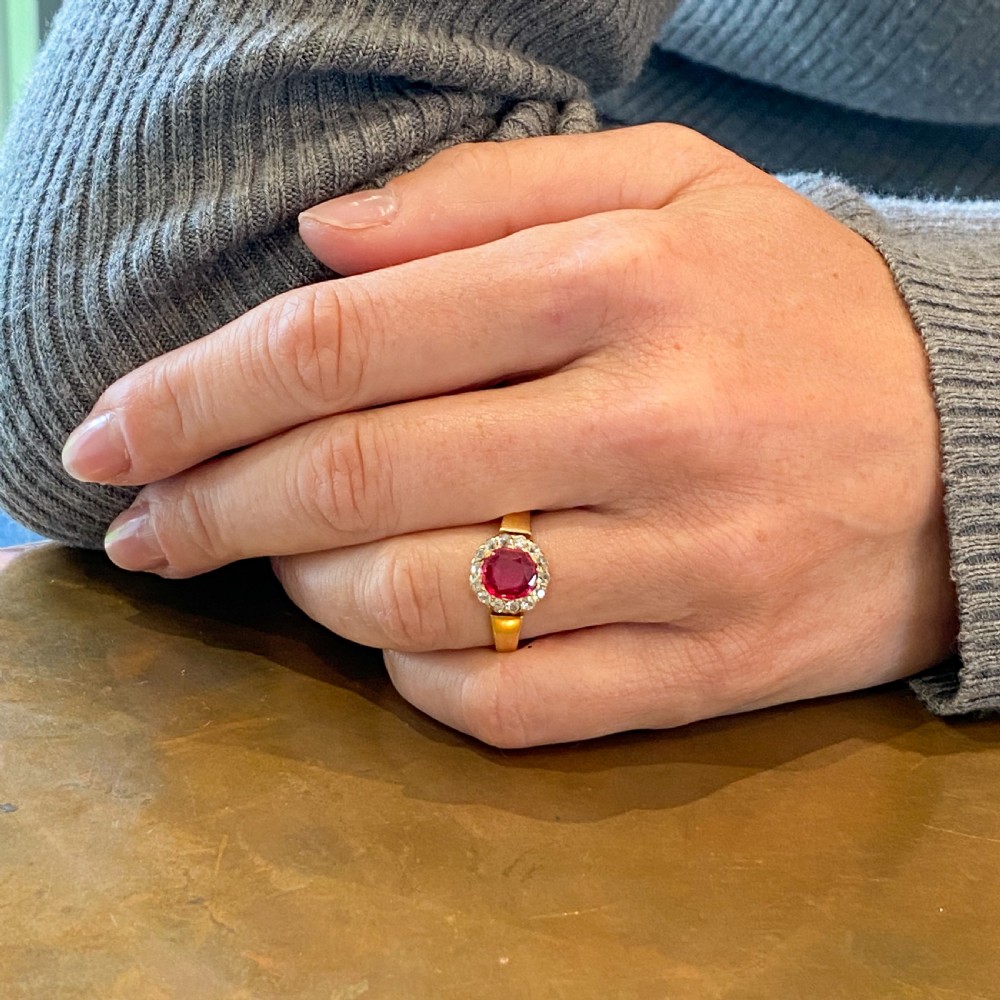 A Victorian yellow gold ring featuring a central cushion-cut pinkish-red Burmese spinel surrounded by a halo of small diamonds. View VIII