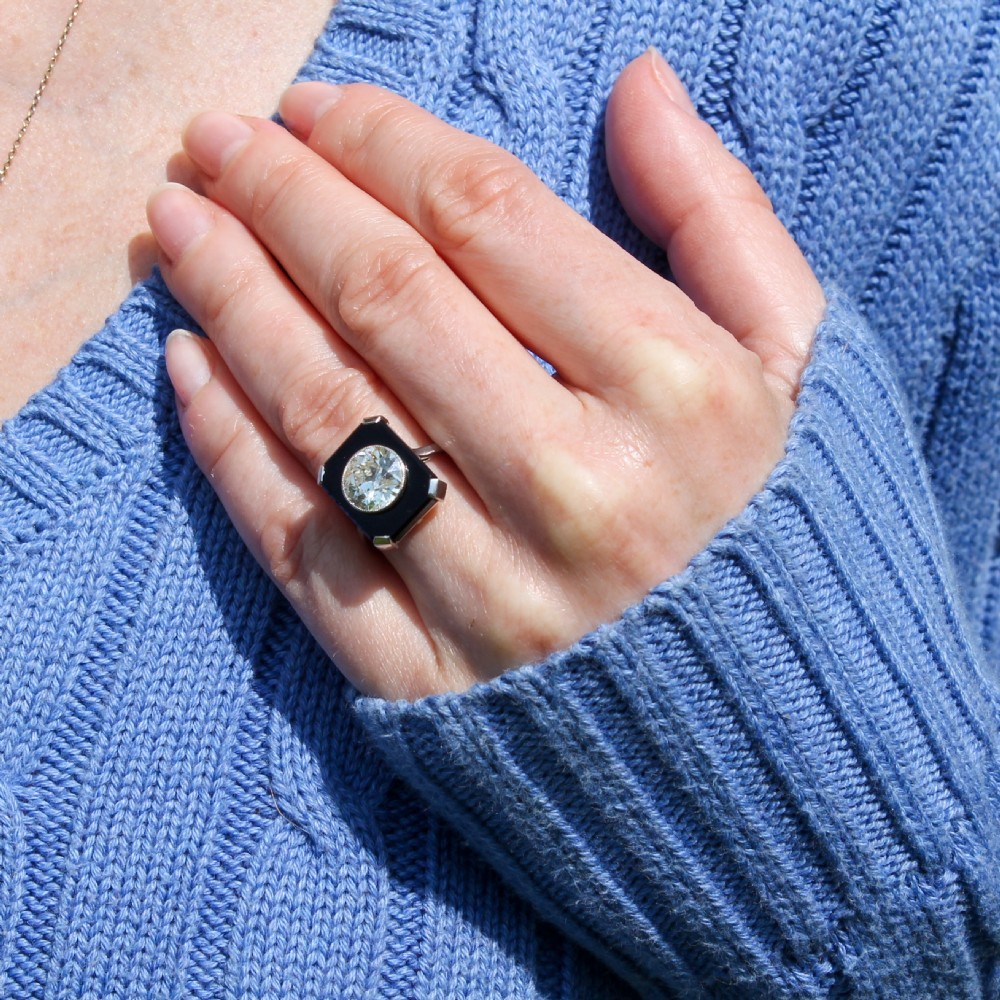 Art Deco platinum ring featuring a central round diamond set within a rectangular black onyx plaque. View VII