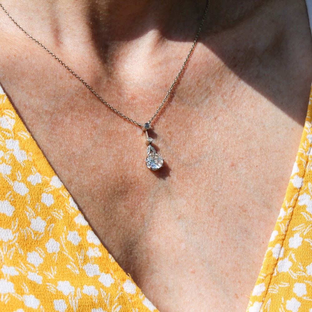 A mid-century diamond pendant featuring a central old cut diamond suspended from an articulated linear drop setting on a trace chain. View III