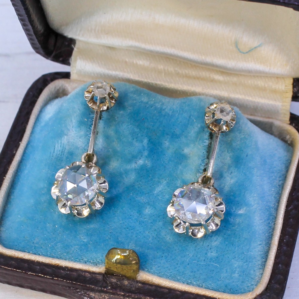 A pair of Art Deco diamond drop earrings featuring rose cut diamonds set in a linear articulated design.