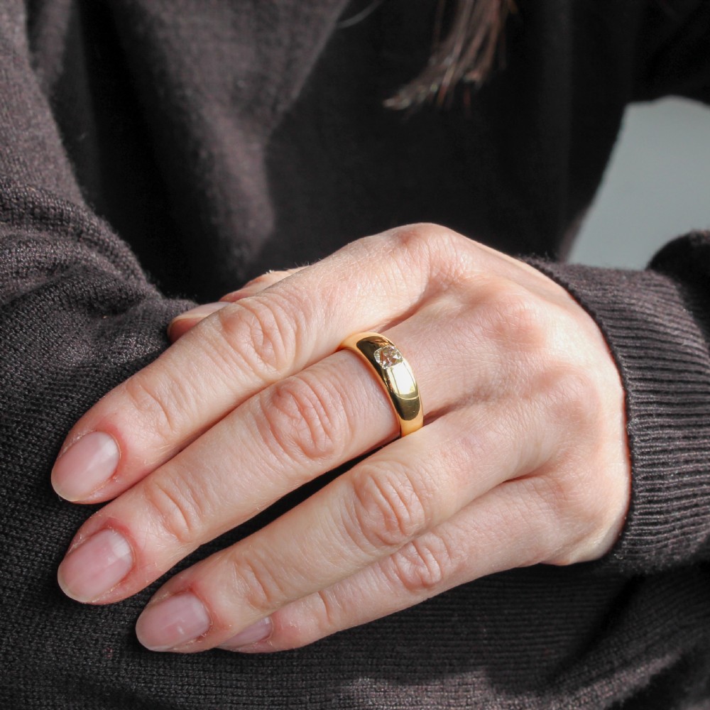 A smooth yellow gold band ring featuring a single flush-set old cut diamond at its centre. View II
