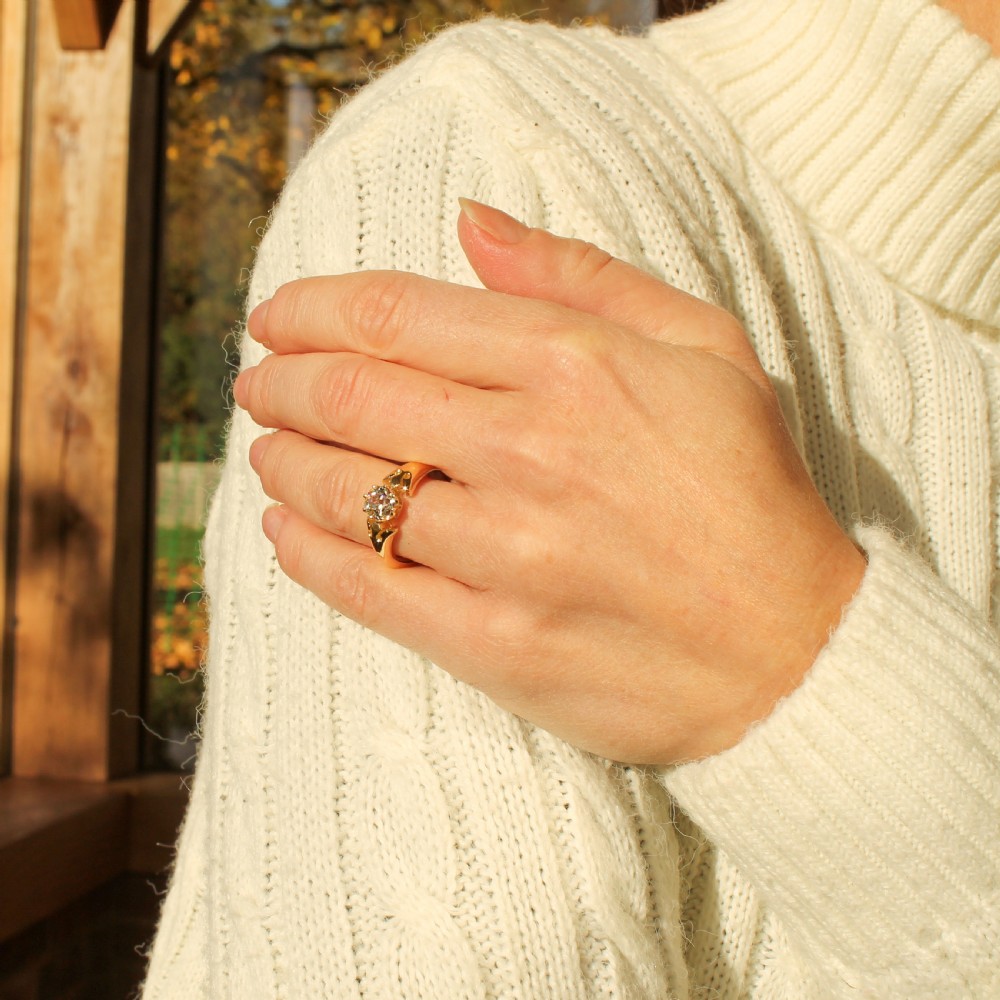 A mid-century yellow gold solitaire ring featuring a single round old-cut diamond held in a claw setting with sculpted shoulders. View VII