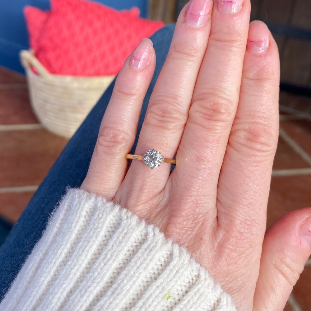An Art Deco diamond solitaire engagement ring with an old cut diamond set in white metal claws on a yellow gold band. View VI