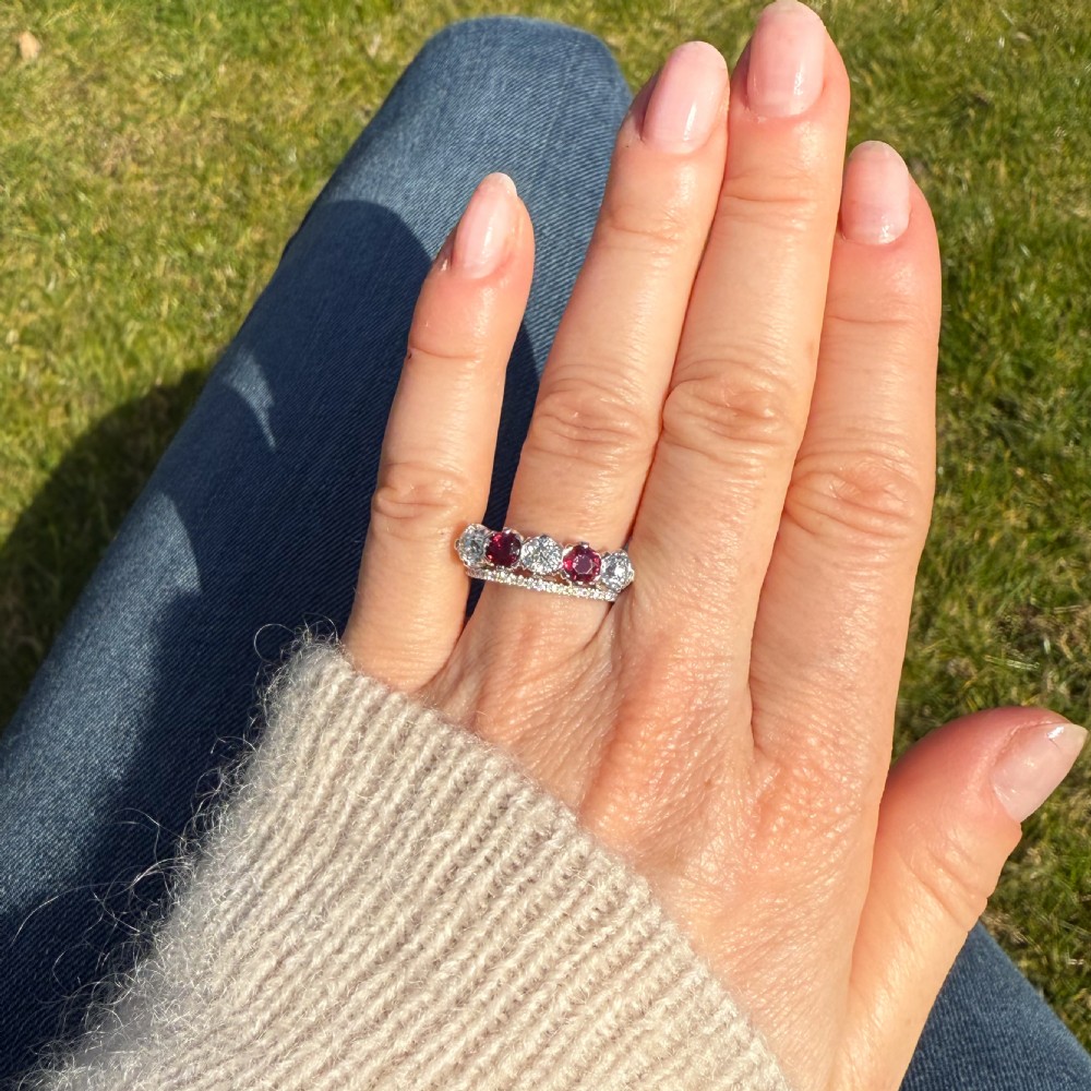 A mid-century white metal five stone ring set with alternating round red rubies and old cut white diamonds. View VII
