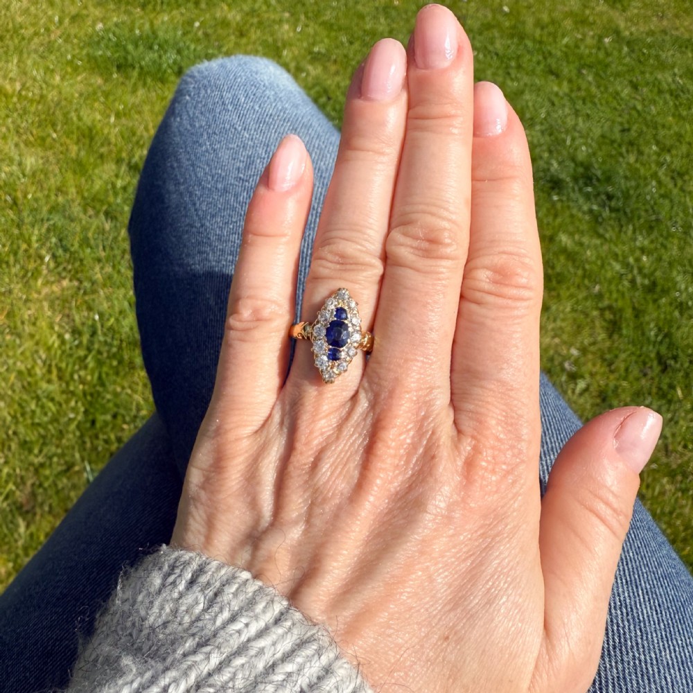 A late Victorian yellow gold ring featuring an elongated marquise cluster set with central blue sapphires surrounded by old cut diamonds. View VII