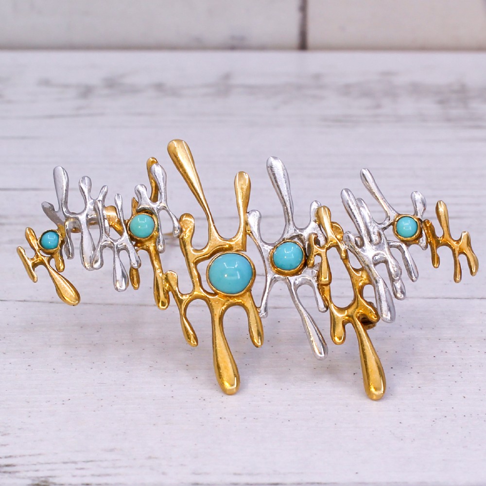 An abstract 1960s bi-metal gold brooch featuring molten openwork structures set with circular turquoise cabochons.