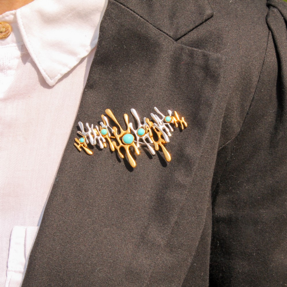 An abstract 1960s bi-metal gold brooch featuring molten openwork structures set with circular turquoise cabochons. View II