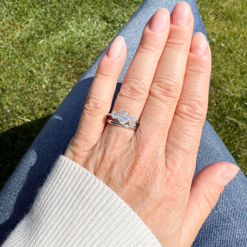 An Art Deco platinum ring set with three old-cut diamonds in a horizontal trilogy configuration. View VI