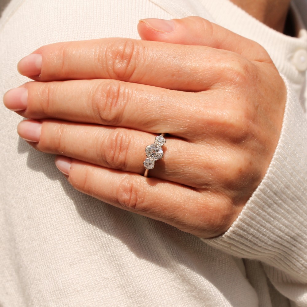 An Art Deco platinum ring set with three old-cut diamonds in a horizontal trilogy configuration. View VIII