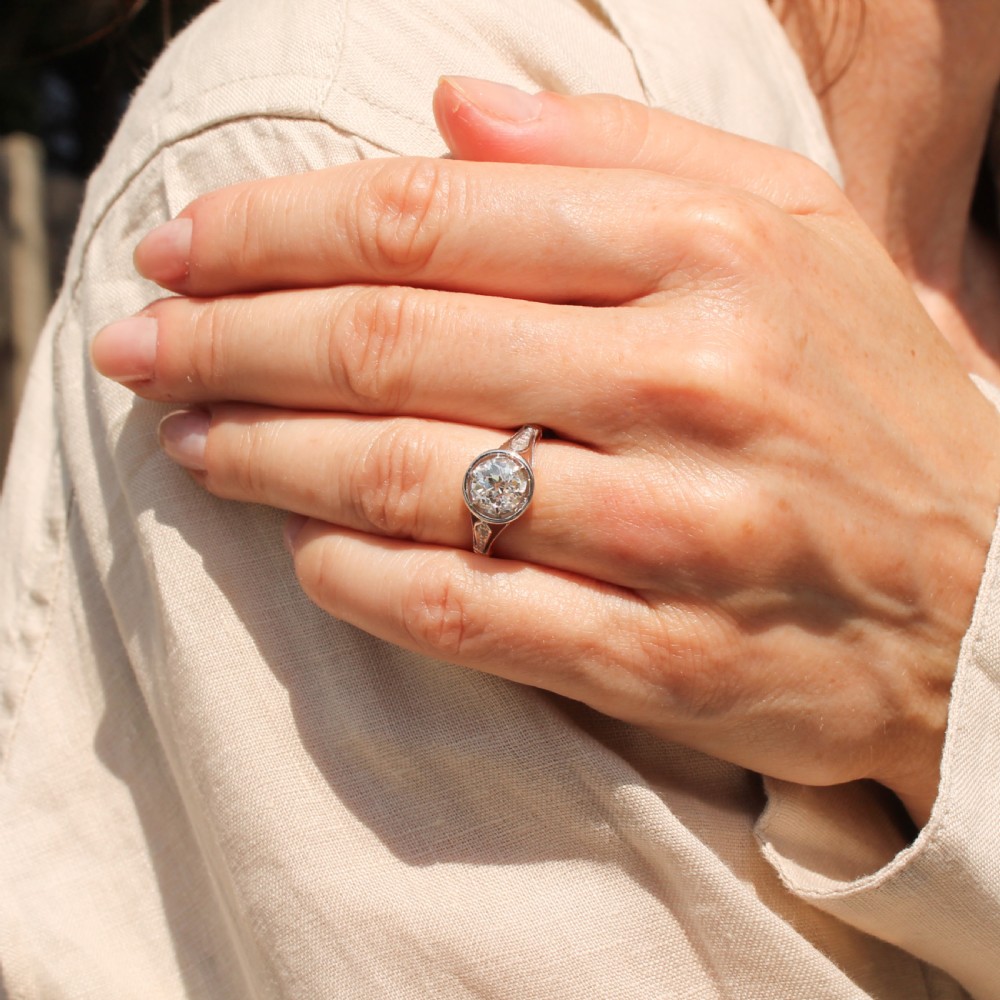 A mid-century engagement ring featuring a central old cut diamond set in a white metal bezel head with accent shoulders on a gold band. View VII