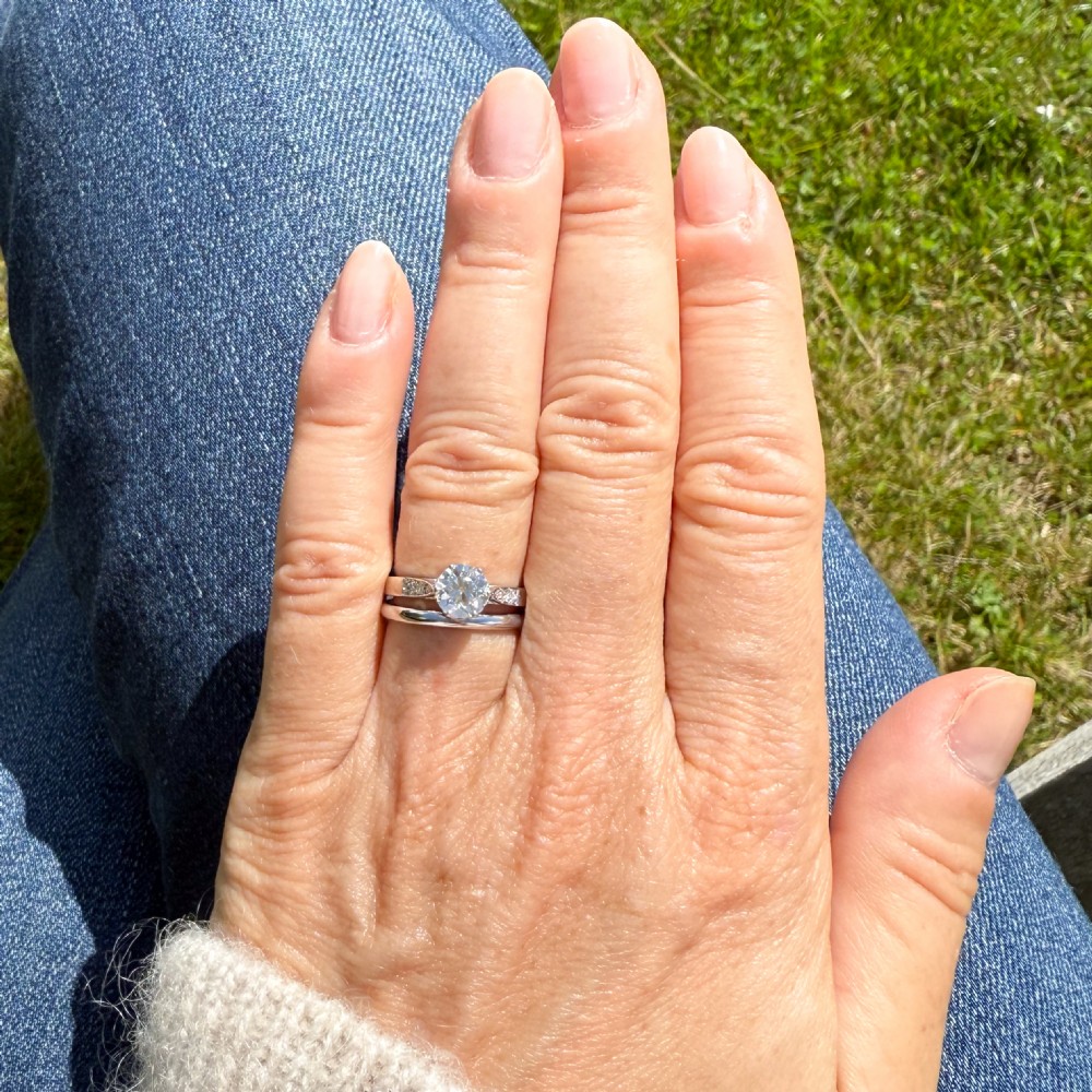 An Art Deco platinum engagement ring set with a round old European cut diamond and accent diamonds along the shoulders. View VI