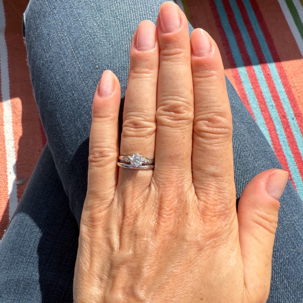 An Art Deco platinum engagement ring featuring a central round old cut diamond set in a coronet mount with detailed diamond shoulders. View VII