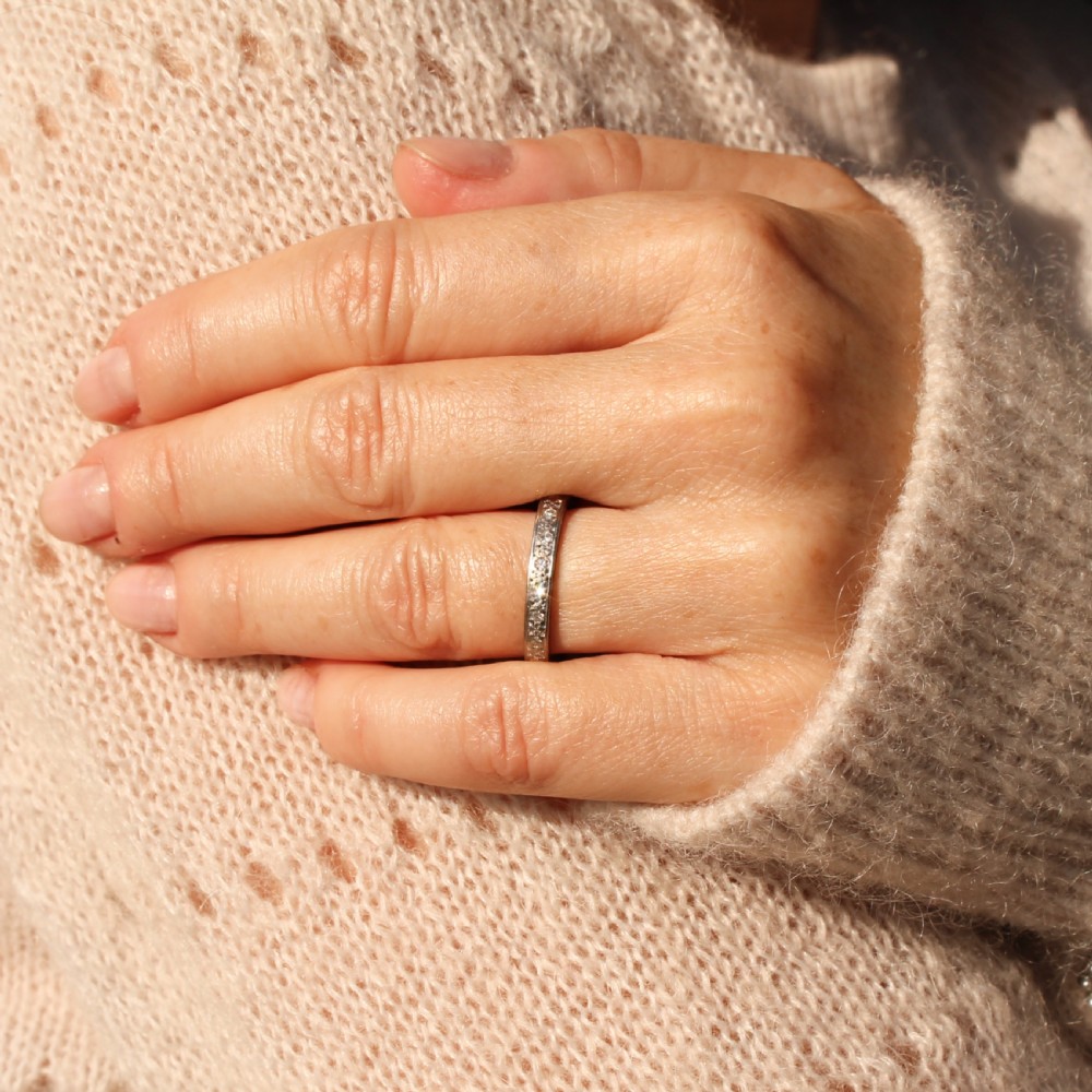 A vintage 18k white gold full eternity ring channel set with a continuous band of diamonds and engraved side detailing. View II