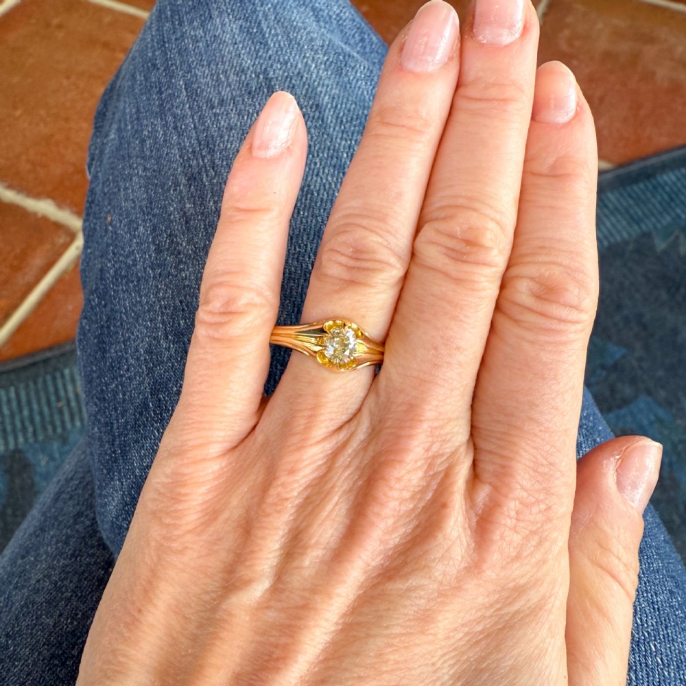 A late Victorian yellow gold ring featuring a single central antique cut fancy yellow diamond in a carved setting. View VII