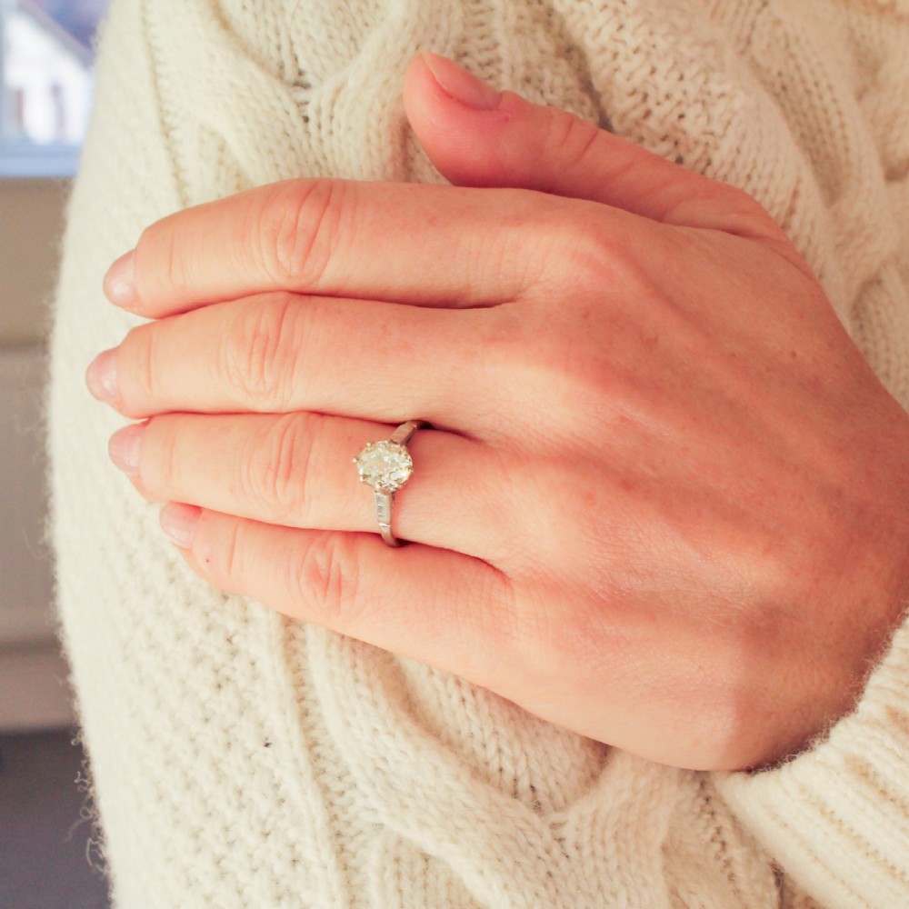 An Art Deco diamond ring featuring an old oval cut diamond set in a silver-toned band with stepped shoulders. View VIII