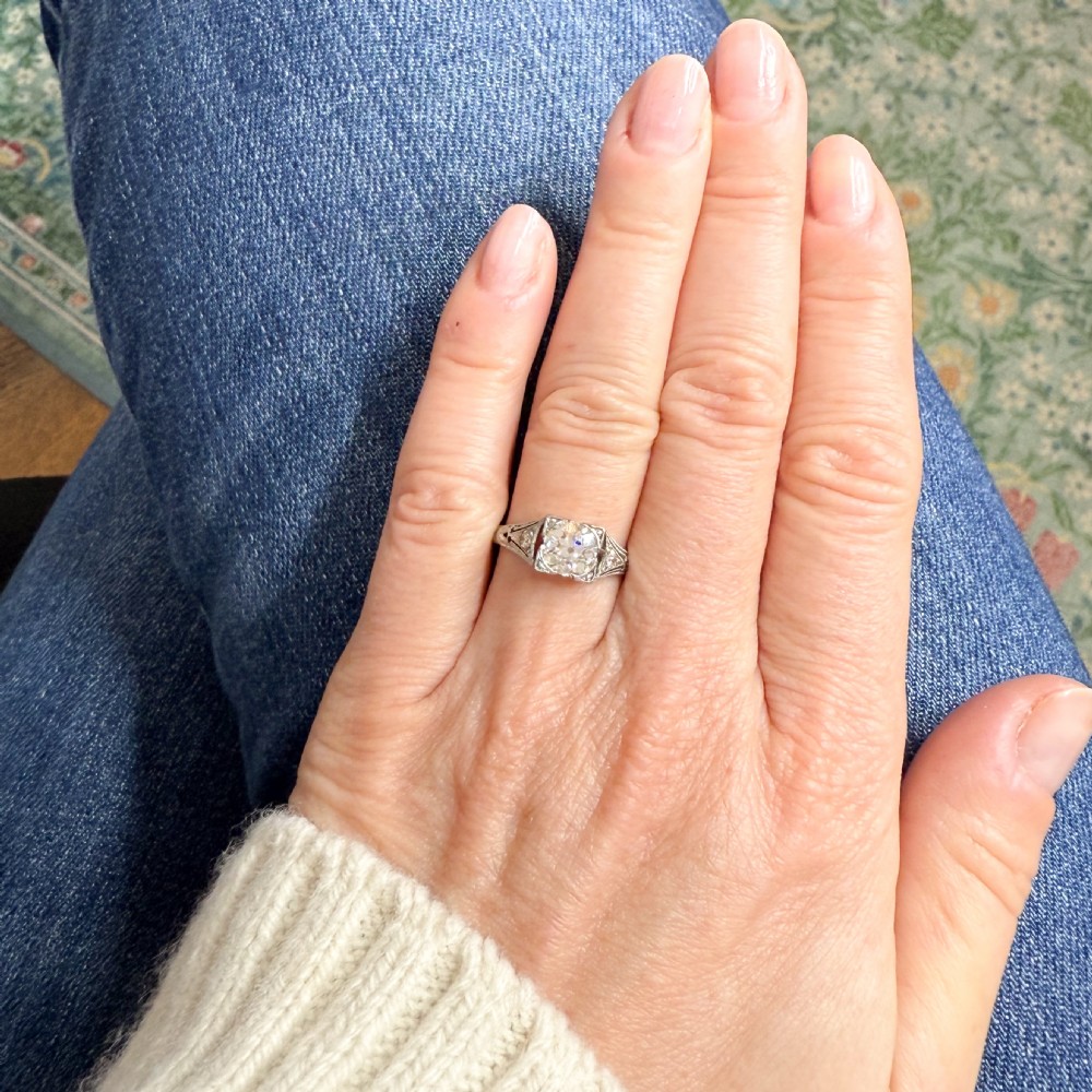 A platinum vintage engagement ring featuring a central old cut diamond set within a square frame and accented by milgrain detail on the shoulders. View VII