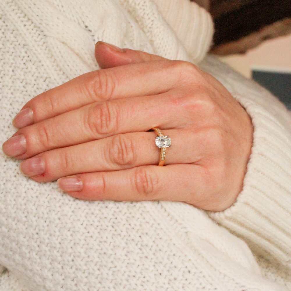 A yellow gold ring set with a cushion-shaped old mine cut diamond in platinum claws and accent diamonds along the shoulders. View VIII