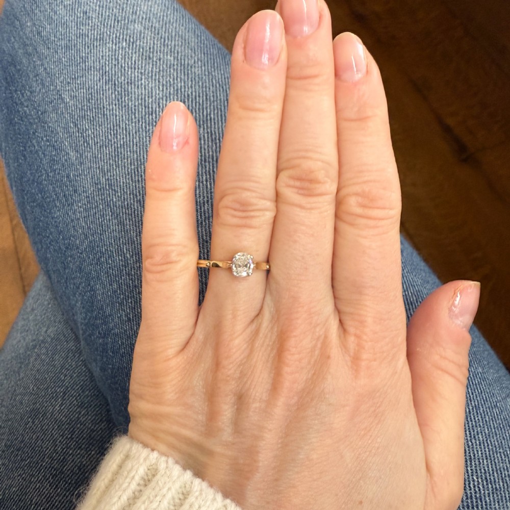 An antique yellow gold solitaire ring featuring a central old cut diamond in a platinum claw setting. View VI