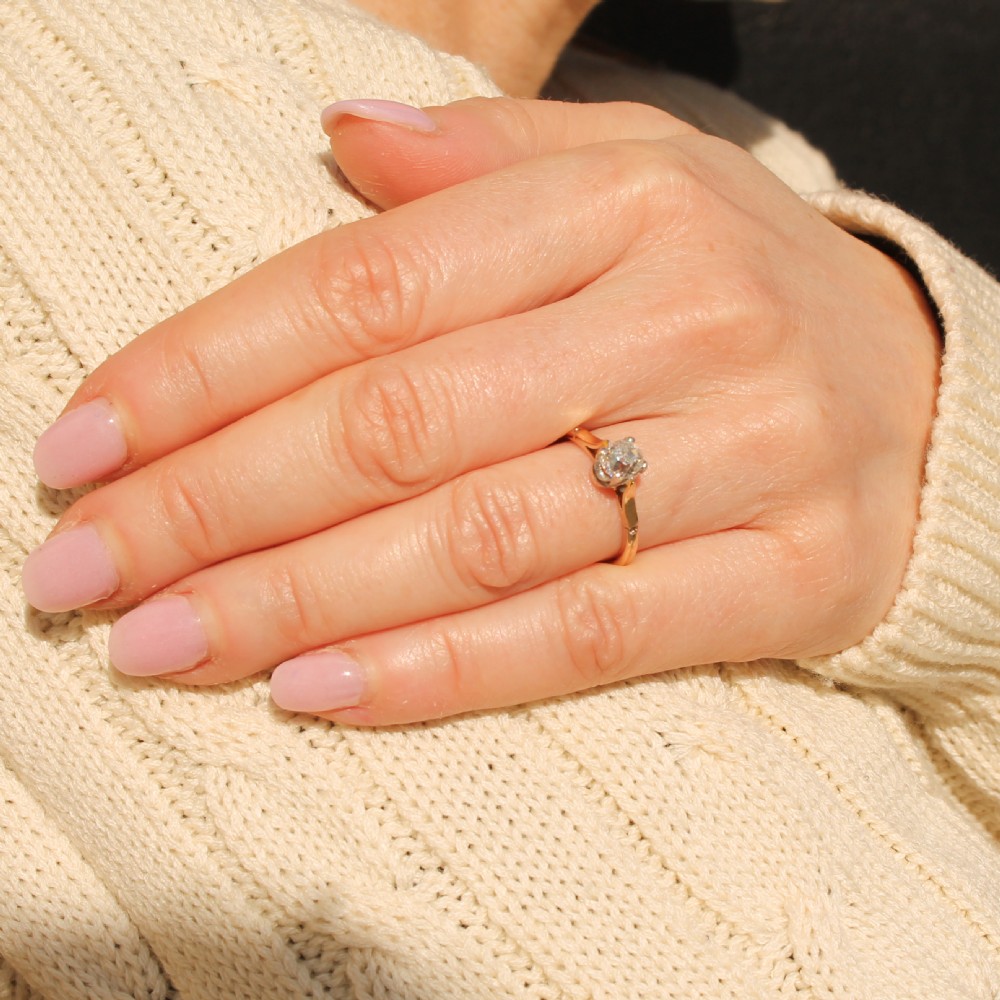 An antique yellow gold solitaire ring featuring a central old cut diamond in a platinum claw setting. View VII