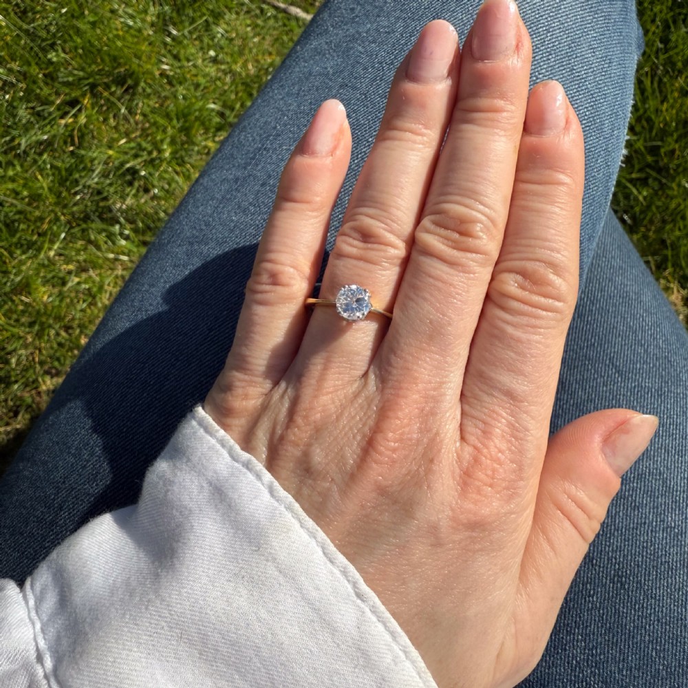 A vintage solitaire engagement ring featuring an old cut diamond in a multi-claw platinum setting on a polished yellow gold band. View VI