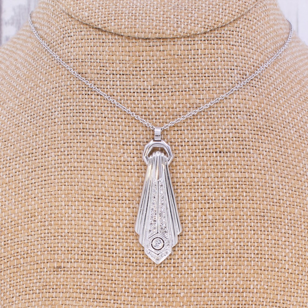 An Art Deco diamond drop pendant featuring geometric fluted metalwork set with brilliant-cut diamonds on a fine silver chain. View IV
