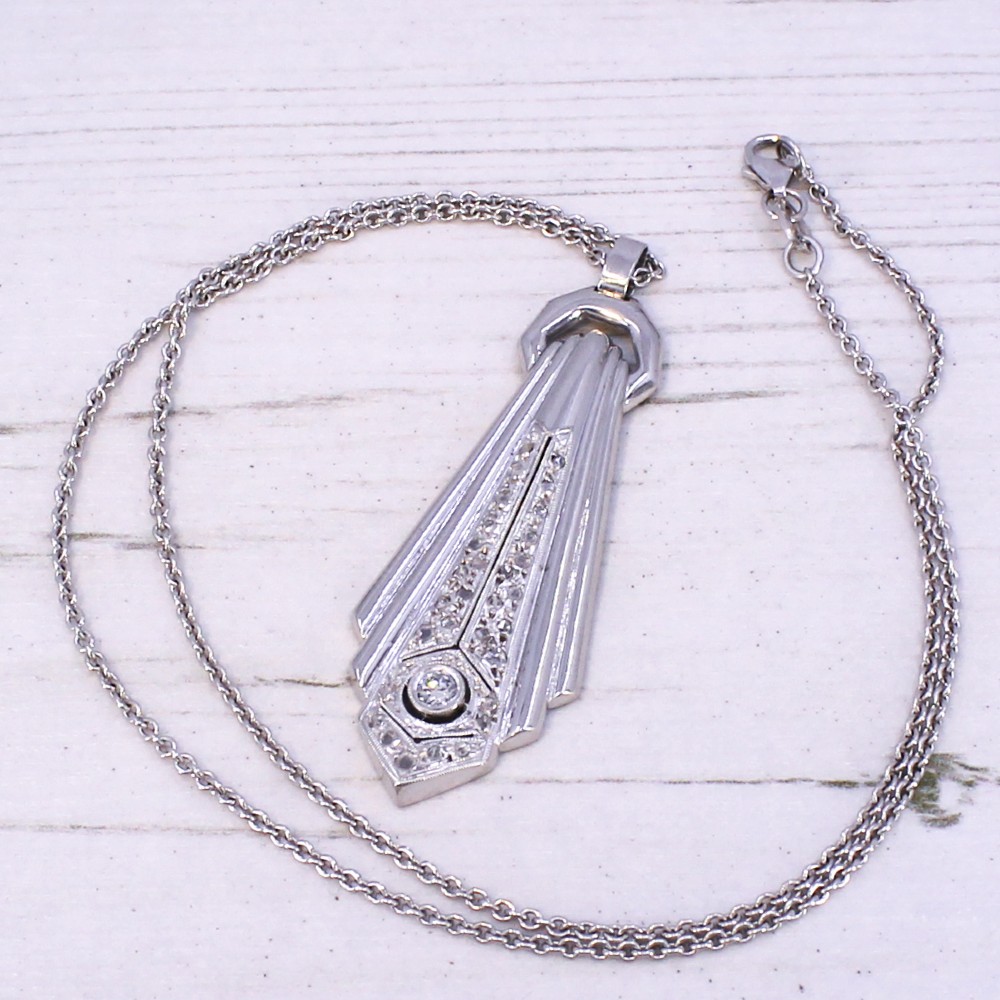 An Art Deco diamond drop pendant featuring geometric fluted metalwork set with brilliant-cut diamonds on a fine silver chain. View V