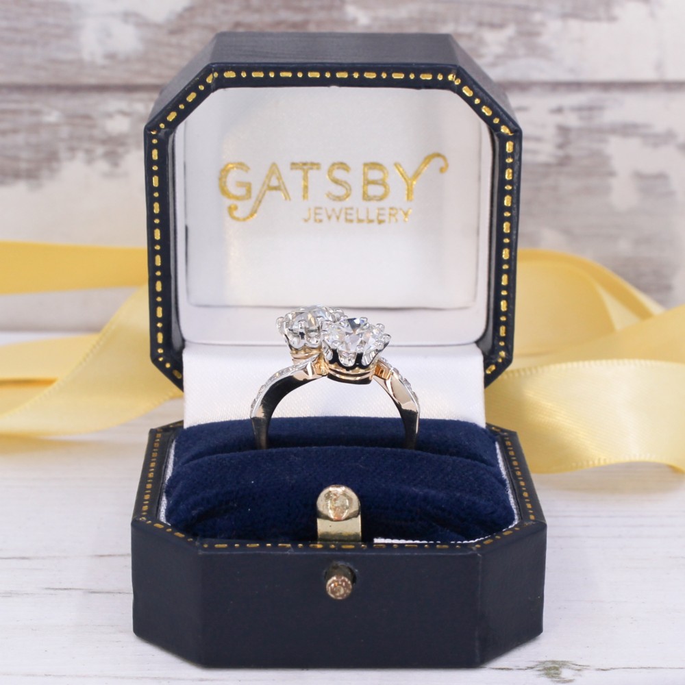 A vintage two-stone diamond Toi et Moi ring featuring two old European cut diamonds set in claw settings with a yellow gold band and diamond-paved shoulders. View X