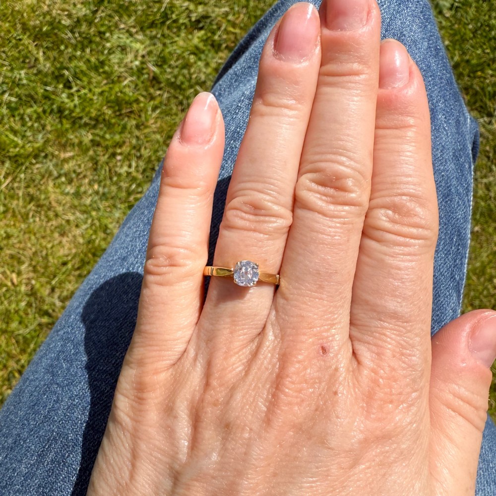 A yellow gold solitaire ring featuring a central cushion shaped old cut diamond with geometric shoulder accents. View VI