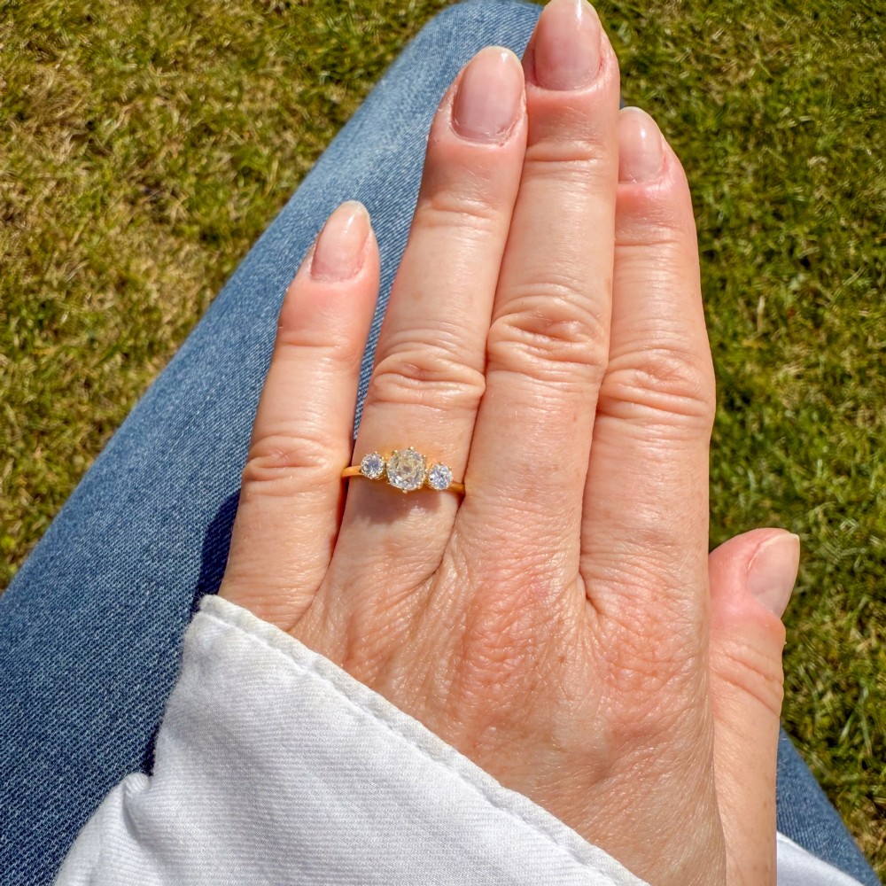 An Edwardian yellow gold trilogy ring featuring three old-cut diamonds set in claw mountings. View VI