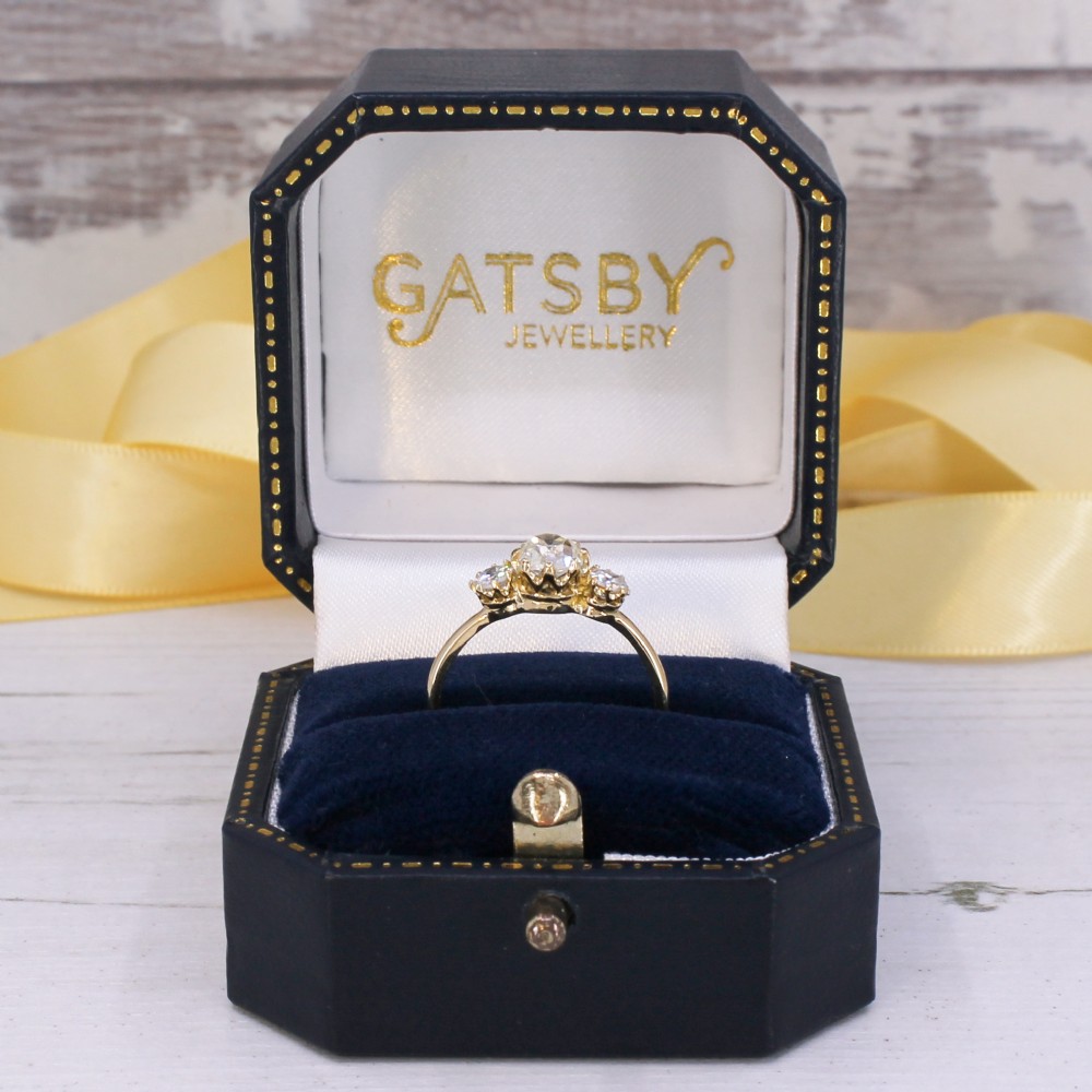 An Edwardian yellow gold trilogy ring featuring three old-cut diamonds set in claw mountings. View IX