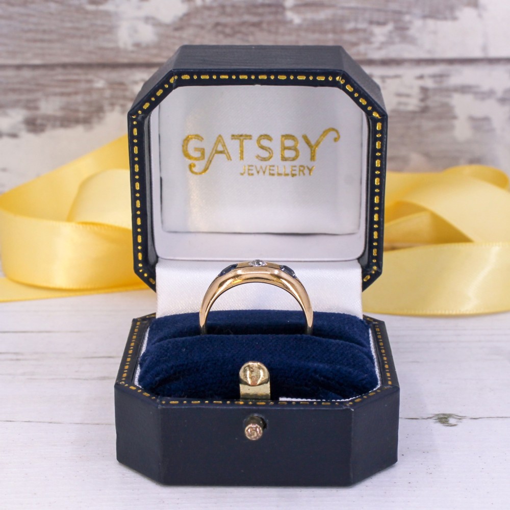 An antique yellow gold gypsy band set with a central old cut diamond flanked by two oval blue sapphires. View VIII