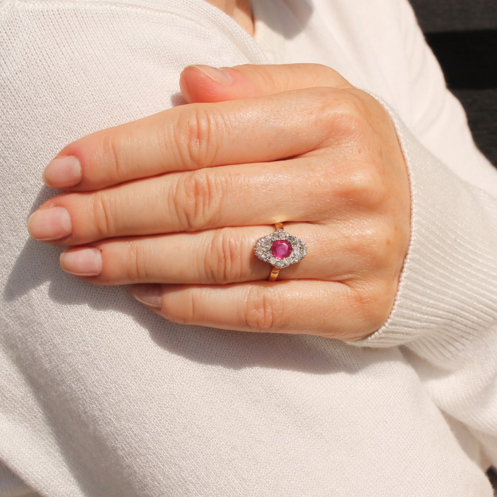 A Victorian ruby and diamond cluster ring featuring an oval red central ruby encased by old-cut diamonds on a yellow gold band. View VII
